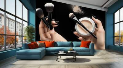 Makeup brush and powder in hands on a dark background Wall mural