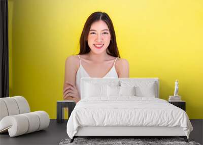 Asian beautiful woman standing arms folded with confidence and empty copy space over yellow background Wall mural