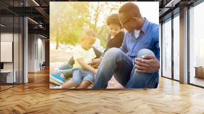 Happy African American father, son and daughter enjoying joyful moment together in the outdoor park Wall mural