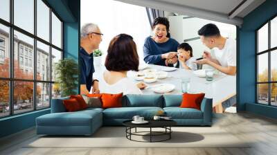 Happy Asian extended family having dinner at home full of laughter and happiness Wall mural