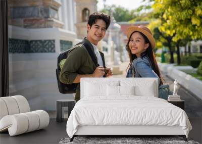 Portrait of Asian man and woman travel couple backpackers in relationship inside of buddhist temple on the street in Bangkok, Thailand, Southeast Asia - carefree and happy traveling concept Wall mural