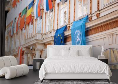 Set of European Union flag and United Nations flags hanging on building in Vienna, Austria, Europe Wall mural