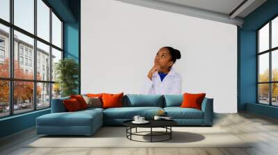 Young preteen African American kid wearing lab coat thinking and questioning in white isolated background Wall mural