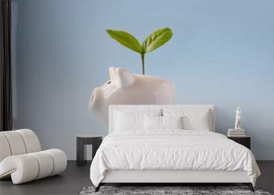 Piggy bank with growing plant on top. Conceptual financial growth still life. Wall mural