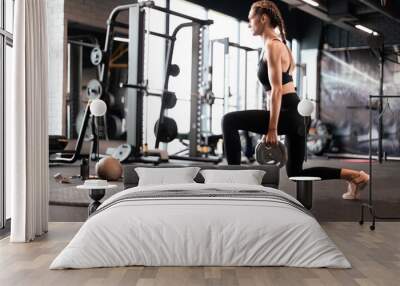 Beautiful muscular fit woman exercising building muscles. Wall mural