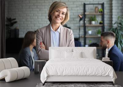 Business woman with her staff, people group in background at modern bright office indoors. Wall mural