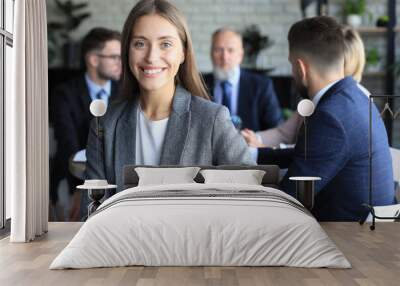 Business woman with her staff, people group in background at modern bright office indoors. Wall mural