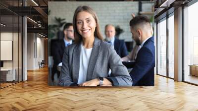 Business woman with her staff, people group in background at modern bright office indoors. Wall mural