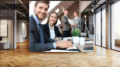 Businessman with colleagues in the background in office. Wall mural