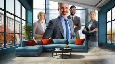 Businessman with colleagues in the background in office. Wall mural