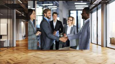 Confident business people shaking hands at workplace. Wall mural