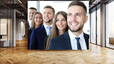 Happy smiling business team standing in a row at office Wall mural