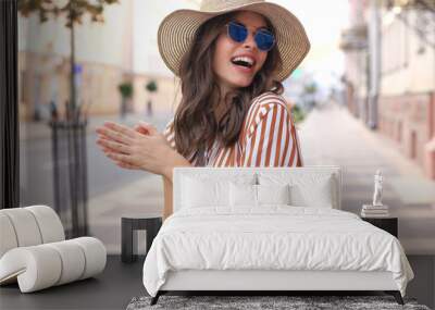 Portrait fashion woman is posing in the city, summer street fashion. Laughing and smiling portrait. Wall mural