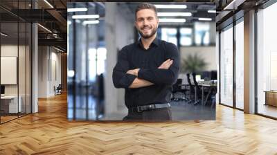 Portrait of a happy young casual businessman at office Wall mural