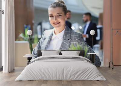 Portrait of a young blond business woman using computer at office. Wall mural