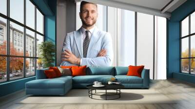 Portrait of happy businessman with arms crossed standing in office Wall mural