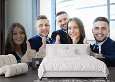 Portrait of happy businesspeople standing in office showing thumb up Wall mural