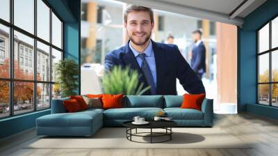 Portrait of young man sitting at his desk in the office. Wall mural