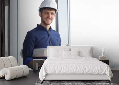 Shot of male architect wearing hardhat and inspecting new building. Wall mural