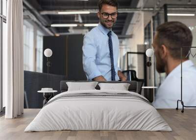 Two business colleagues shaking hands during meeting. Wall mural