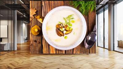 On the wooden table, there is a cream soup with fresh mushrooms as the base Wall mural