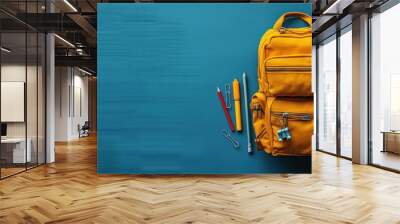 Yellow Backpack with School Supplies on Teal Background Wall mural