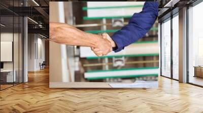 Cropped Image Of Carpenters Shaking Hands Wall mural