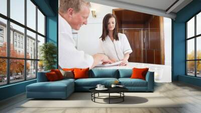 mature man standing at a spa reception Wall mural