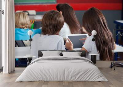 Schoolgirl Using Digital Tablet At Desk Wall mural