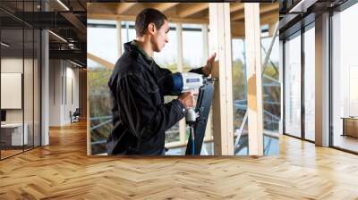 Side View Of Male Carpenter Drilling Wood At Site Wall mural