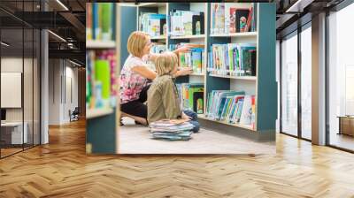 Teacher Assisting Boy In Selecting Books In Library Wall mural