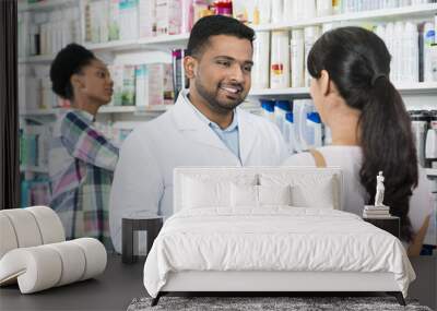 Young Chemist Assisting Female Customer Wall mural