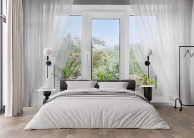 Window with white tulle and potted plants on windowsill Wall mural