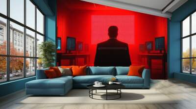 A man is sitting in a chair in front of a large red screen Wall mural