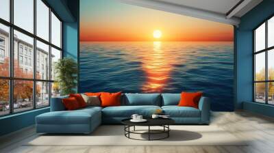 The sun is setting over the ocean, casting a warm glow on the water Wall mural