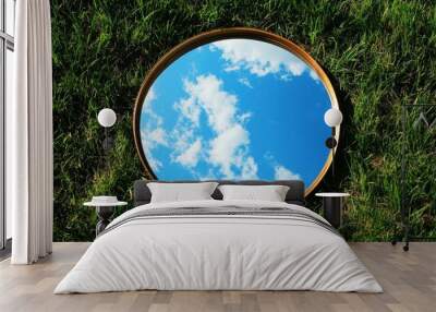 Reflection of blue sky and clouds in a round mirror on grass - nature concept Wall mural