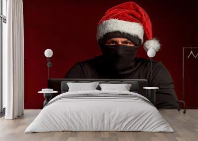 Santa hacker holding laptop computer, anonymous man on black background, cyber attack and internet security on Christmas holiday background. Wall mural