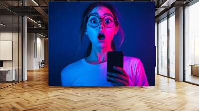 Social media post, blogging. Concept of human emotions, online communication. Beautiful young girl taking selfie with mobile phone against gradient blue studio background. Wall mural