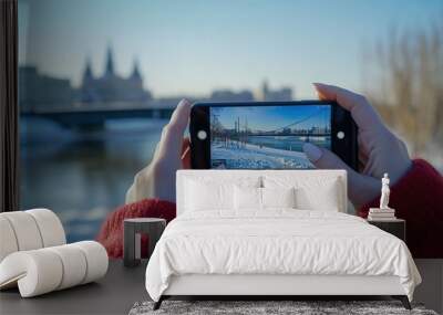 woman taking a photo of a bridge with a smartphone close-up view Wall mural