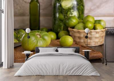 Closeup of green tomatoes on the wooden cutting board and in basket.Process of preparation of green tomatoes preservation Wall mural