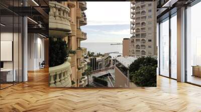 A sea view between two mediterranean style residential block of flats. Blue sky with white clouds at the background. Wall mural