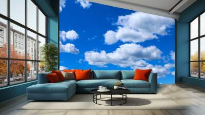 Nice small clouds. Cute fluffy cirrus clouds on a blue sky, background with a gradient effect. Postcard cloudscape Wall mural