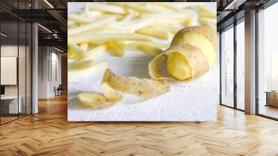 Potatoes with peel and chips on white board Wall mural