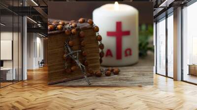 Wooden cross with bible, rosary and paschal candle, easter religious concept  Wall mural