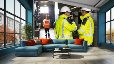 Facility for Construction of Oil, Gas and Fuel Pipeline Transportation Products. Two Heavy Industry Engineers Stand in Pipe Manufacturing Factory, Use Digital Tablet Computer, Have Discussion Wall mural