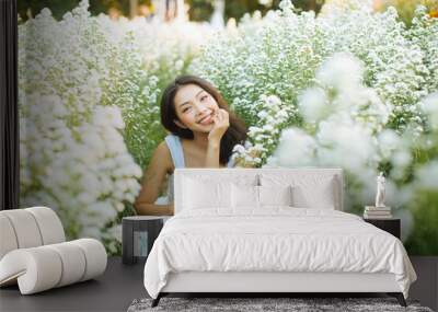 Asian woman in a white dress posing in garden Wall mural