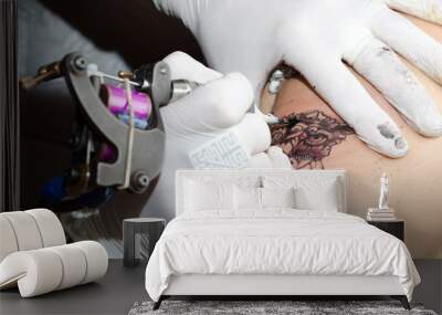 Tattoo artist makes the tattoo on arm Wall mural