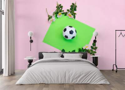 Soccer ball, white and black and flowers on dual color background. fashion concept. minimalism. Flat lay, top view, copy space Wall mural