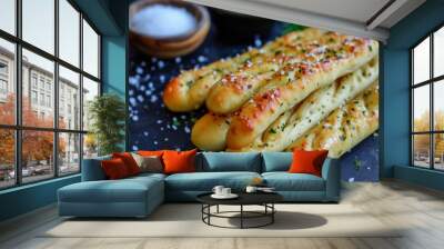 Grissini breadsticks with olive oil and herbs on black background Wall mural