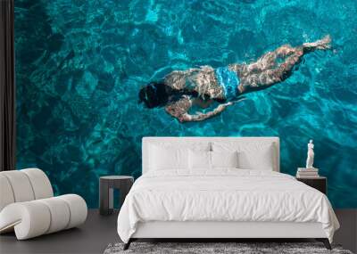 Top view photo. A young girl dives and snorkels in the clear turquoise Aegean Sea. Summer sea voyage and relaxation in a beautiful bay. Wall mural